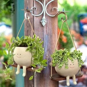 Resin hanging flower pot with playful face design
